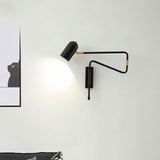 "Black and gold adjustable arm bedside reading lamp mounted on a white wall."