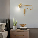 "Gold adjustable arm bedside reading lamp mounted above a nightstand."