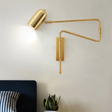 "Gold adjustable arm bedside reading lamp mounted on a bedroom wall."