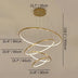Gold spiral chandelier with four illuminated rings suspended from ceiling mount against white wall.