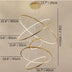 Modern gold and white LED chandelier with stacked orbital rings suspended against a beige ceiling.