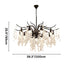 Crystal chandelier with black metal branches and cascading clear glass droplets, shown against white background.