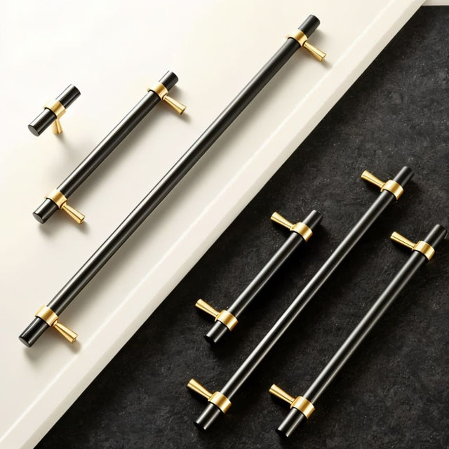 "Set of black and gold brass pull bars with cylindrical design and subtle accents, arranged on a white and dark grey surface."