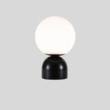 Sibwa Table Lamp with black marble base and white globe, perfect for sleek and modern living room or office lighting.