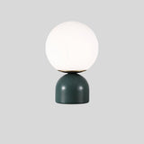 Sibwa Table Lamp with green base and white globe on grey background, ideal for modern ambient lighting in any room.
