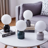 Collection of Sibwa Table Lamps with various marble and metal bases on a round coffee table, showcasing modern lighting options.
