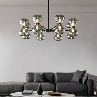 "Black iron Silvine chandelier with smoked glass spherical shades hanging above a living room with a grey leather sofa and marble coffee table."