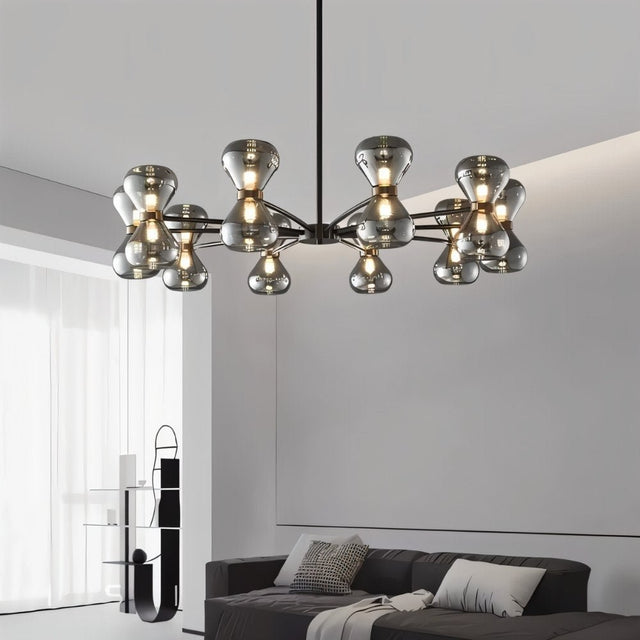 "Black iron Silvine chandelier with smoked glass spherical shades hanging above a living room with a grey sofa and modern décor."