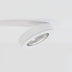 White adjustable downlight with ribbed reflector mounted on ceiling against white background.