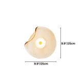 "A modern wall lamp with an amber, organically shaped glass shade and an iron base."