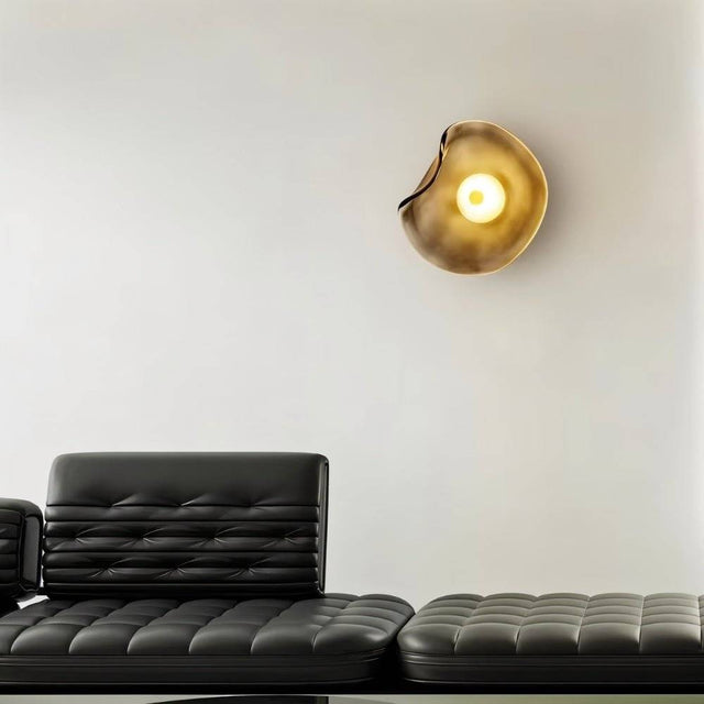 "Modern wall lamp with a fluid, amber glass shade and a sleek iron base."
