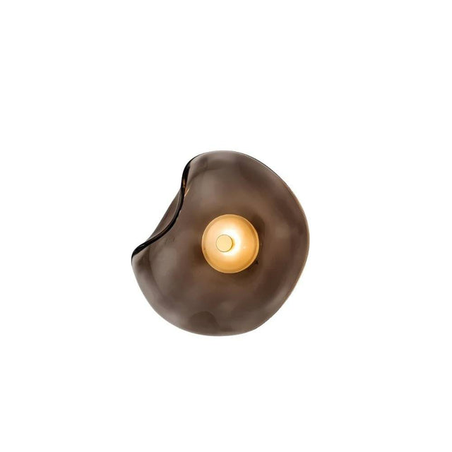 "A modern wall lamp with a fluid, organic-shaped smoky grey glass shade and a sleek iron base."