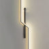 Modern wall lamp with black metal frame and warm LED lighting mounted on a white wall.