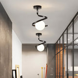 "Two modern black ceiling lights with spiral frames and frosted glass globes in a long hallway with gray walls and a glass partition."