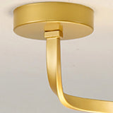 "A close-up detail of the gold Slym ceiling light showing the ceiling mount and curved frame."