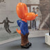 Colorful toy figurine with orange head, blue pants, and brown boots displayed on white surface.