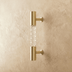 Brass and clear glass cylindrical pull handles mounted on white cabinet doors.