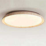 "Close-up of a minimalist ceiling light with a soft yellow travertine ring and acrylic diffuser, emitting a soft, even glow."