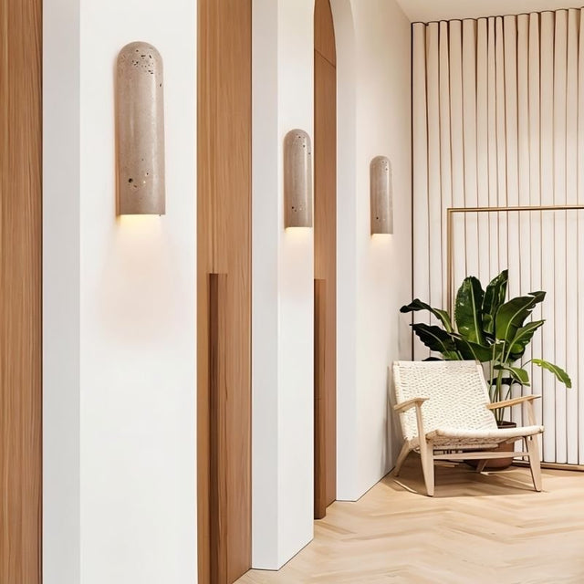 "Solon travertine wall lamps illuminating a stylish living room with natural textures, creating a warm and inviting ambiance."