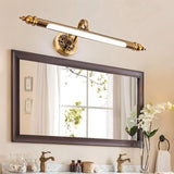 "A retro copper wall lamp with intricate detailing and an elegant rod-shaped light fixture, mounted above a rectangular bathroom mirror with a white countertop and double sinks."