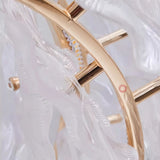 "A close-up detail of a gold ring chandelier with handcrafted glass petals."