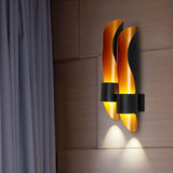 "Modern wall lamp with a flame-inspired design, featuring a dual-tone metal finish and casting a soft, ambient glow."
