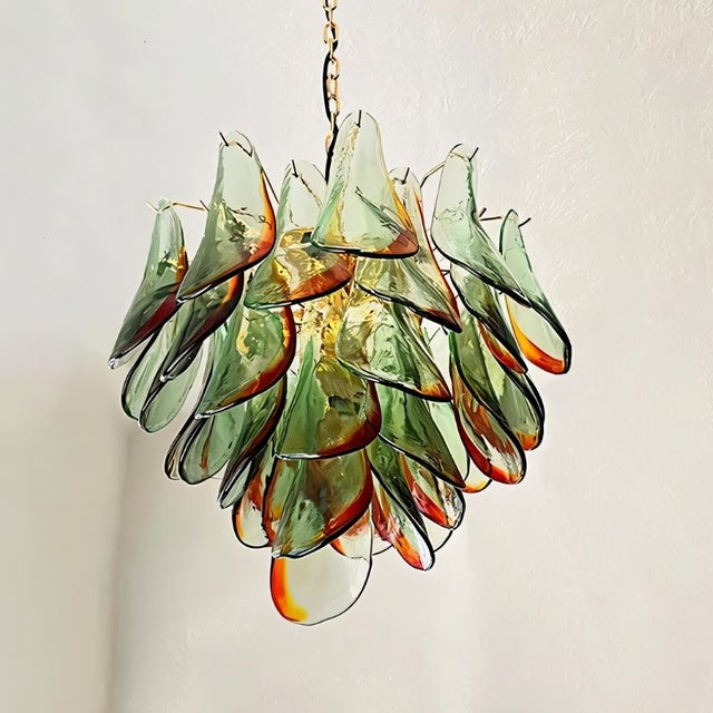 "Close-up of a Murano glass chandelier with green and red accents, showing the intricate glass details."