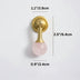 Rose quartz crystal knob with brushed brass hardware on white background.