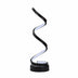 Spiral table lamp with black and white curved design and round base on white background.