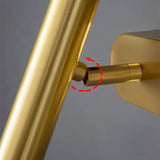 "Close-up of the adjustable gold arm of a bedside reading lamp."