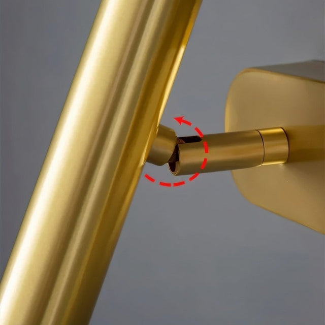 "Close-up of the adjustable gold arm of a bedside reading lamp."