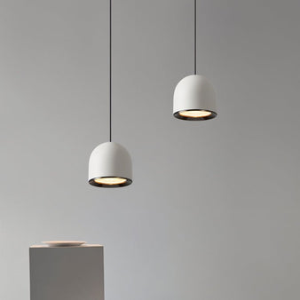 Sterna Pendant Light in white with a modern dome-shaped aluminum design, suspended in a minimalist indoor setting with adjustable cords.