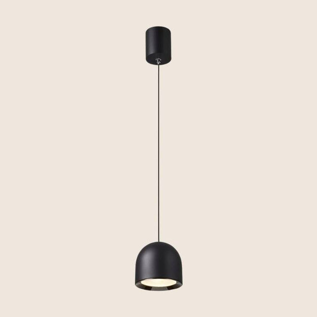 Black Sterna Pendant Light with a dome-shaped aluminum fixture and adjustable cord, shown on a beige background.