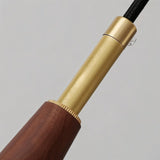 "Close-up of a modern pendant light showing the wood and copper detailing."