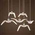 White curved pendant lights with brushed metal fixtures suspended against a brown paneled wall.