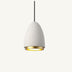 White ceramic pendant light with brass interior ring, suspended by black cord against neutral background.