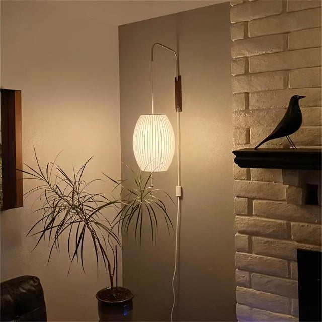 "A modern wall lamp with a luxurious silk shade illuminates a contemporary living room, creating a warm and inviting atmosphere."