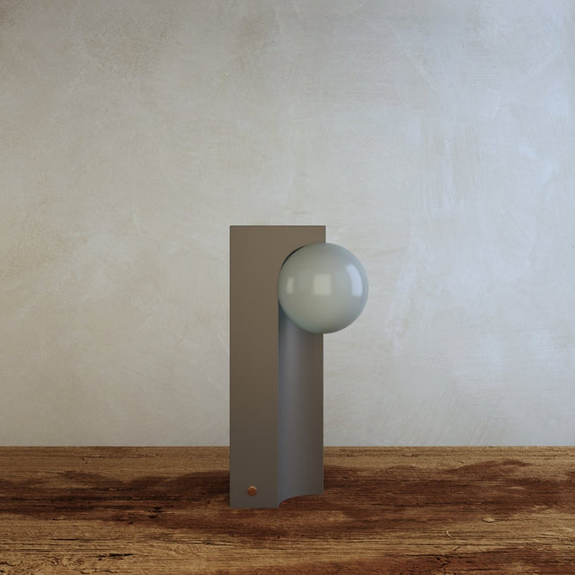 Teral Table Lamp unlit on wooden surface, highlighting its minimalist concrete and glass design for contemporary home decor.