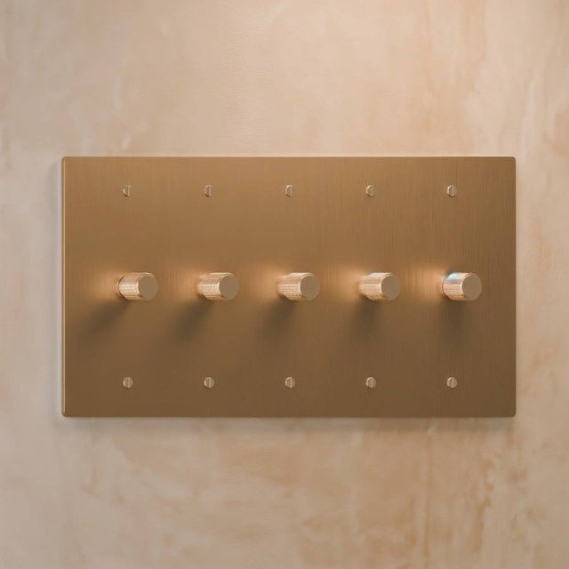 Five-gang light brass rotary dimmer switch with precision knurled knobs, perfect for large-scale lighting control in modern homes.