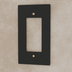 Black metal decorator wall plate with brass screw accents