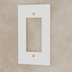 White electrical outlet wall plate with brushed brass screws