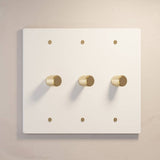 Three-gang white The Brass Dimmer Switch - Open Box with gold knobs, offering stylish lighting control.