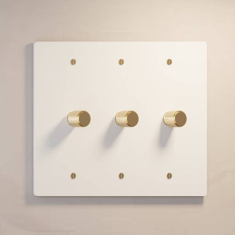 Three-gang white The Brass Dimmer Switch - Open Box with gold knobs, offering stylish lighting control.