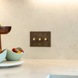 Three-gang The Brass Dimmer Switch - Open Box installed in a modern kitchen backsplash, blending with minimalist decor.