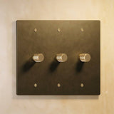Three-gang antique brass The Brass Dimmer Switch - Open Box with textured knobs, perfect for traditional lighting setups.