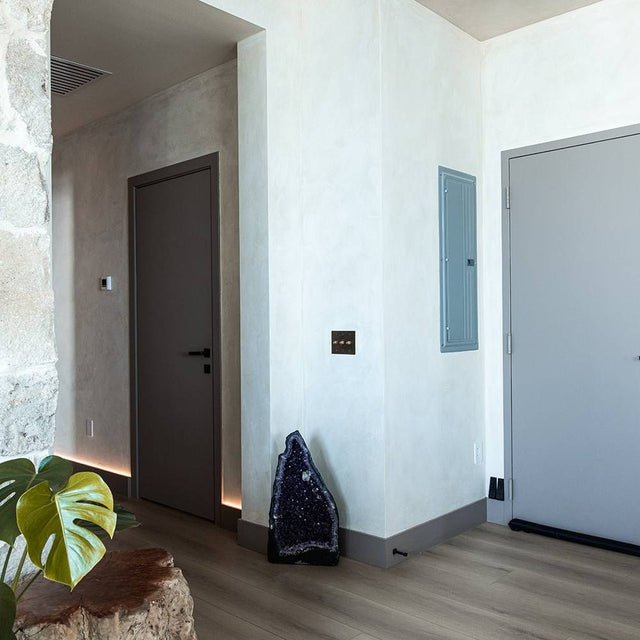 Five-gang The Brass Dimmer Switch - Open Box mounted in a hallway with modern decor and natural stone accents.