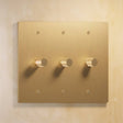 Three-gang The Brass Dimmer Switch - Open Box in polished brass, offering stylish and functional lighting control.