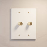 Two-gang The Brass Dimmer Switch - Open Box in white with brass knobs, ideal for bright and modern interiors.