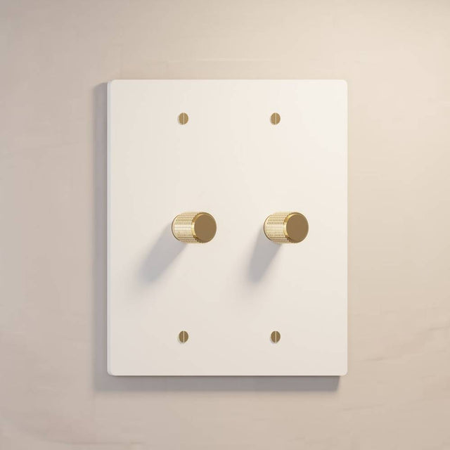 Two-gang The Brass Dimmer Switch - Open Box in white with brass knobs, ideal for bright and modern interiors.