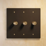 Three-gang matte black The Brass Dimmer Switch - Open Box with brass knobs, perfect for modern home lighting.